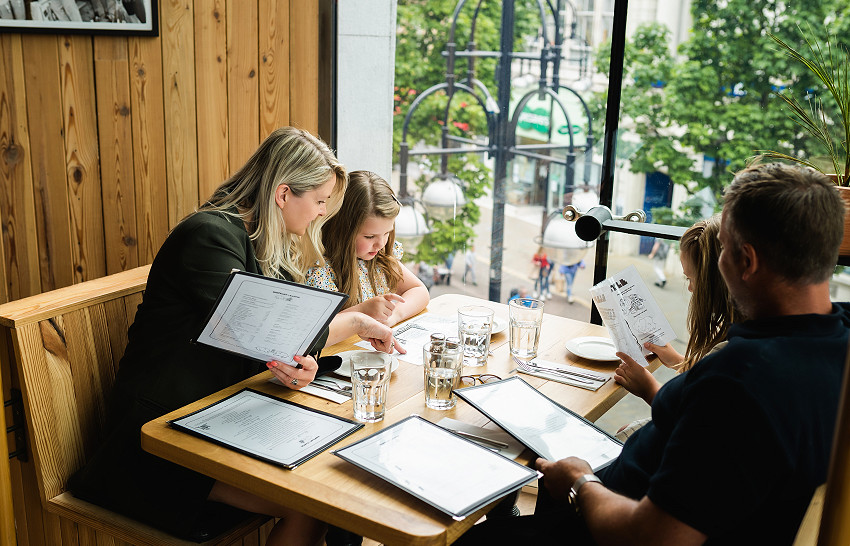 family sat around a table in a restaurant